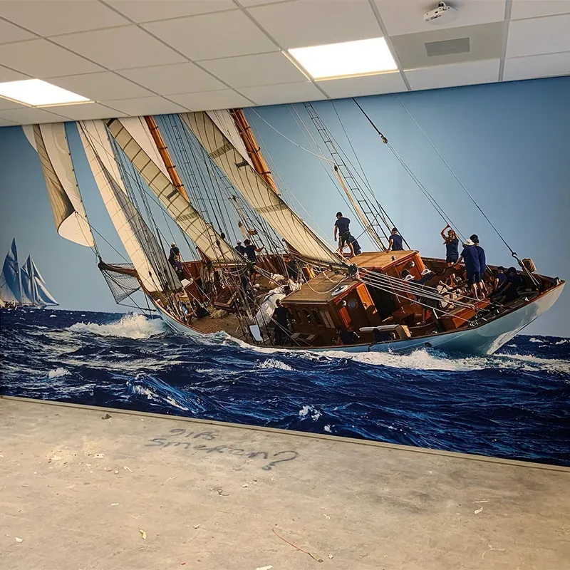 Doek met een zeilschip over de wand van een bedrijfsruimte
