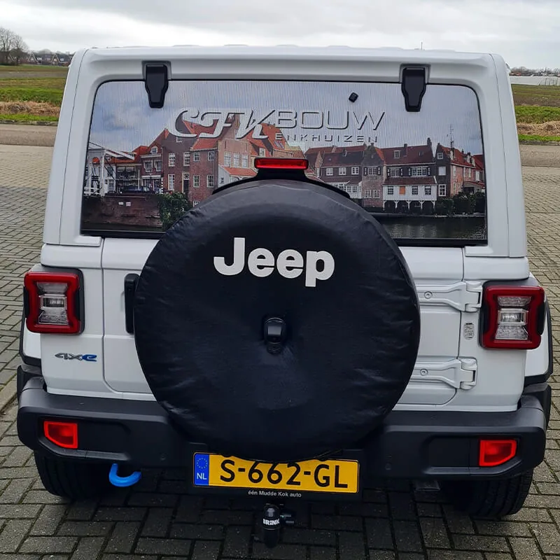Achterruit van een witte Jeep met een geprinte foto van de Enkhuizer havenhuizen en de tekst GTK Bouw