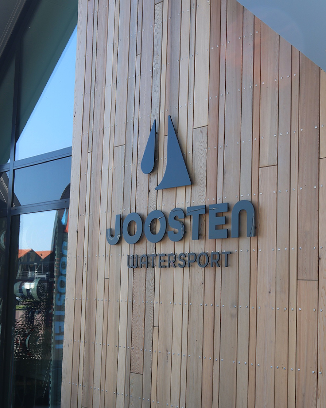Freesletters van Joosten Watersport op de houten gevel