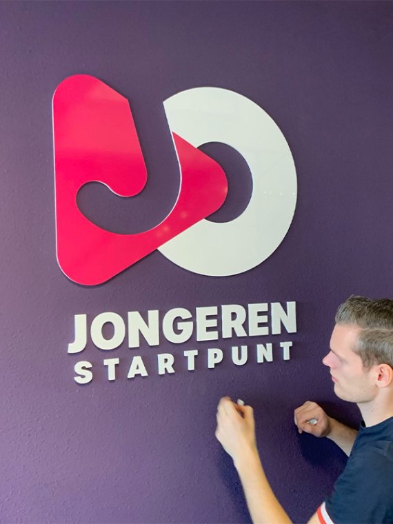 3D-letters van een bedrijfslogo als interieurbranding op een kantoorwand