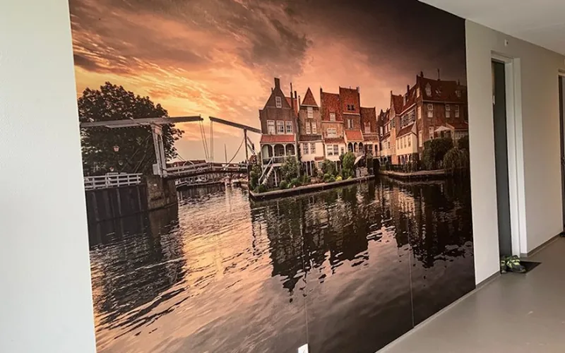 Fotobehang met een havengezicht bij zonsondergang over de wand van een gang