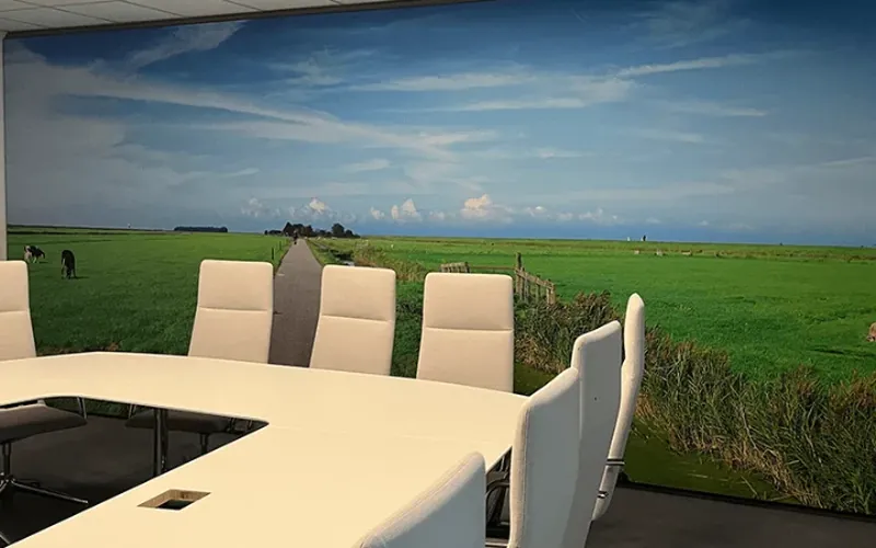 Vergadertafel voor een wandvullende print van een weidelandschap