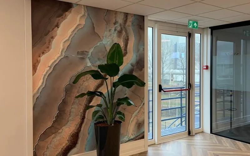 Fotobehang met een abstract steenmotief in aardetinten in een kantoorhal