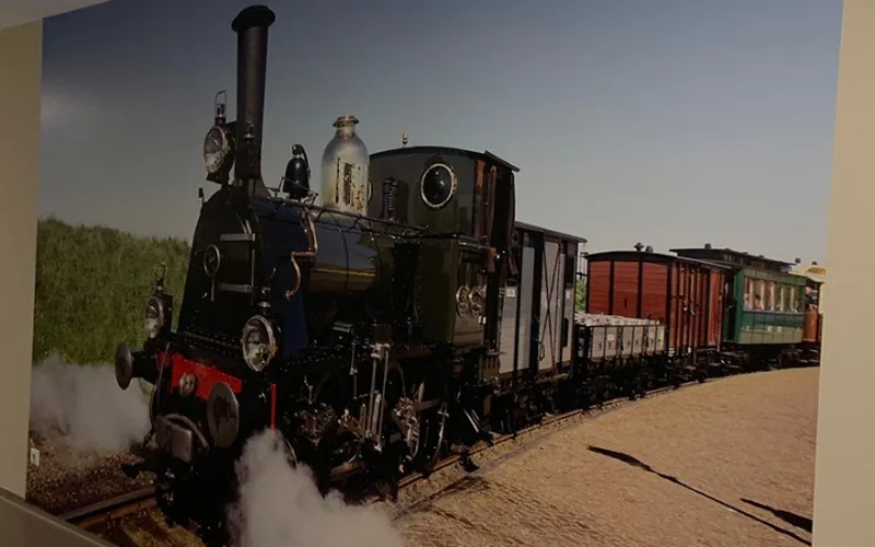 Fotobehang met een stoomlocomotief en goederenwagons over de volle wand
