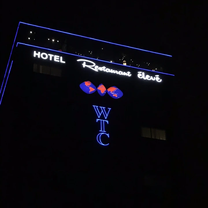 Verlichte 3D-gevelletters bij hotel-restaurant in de avond