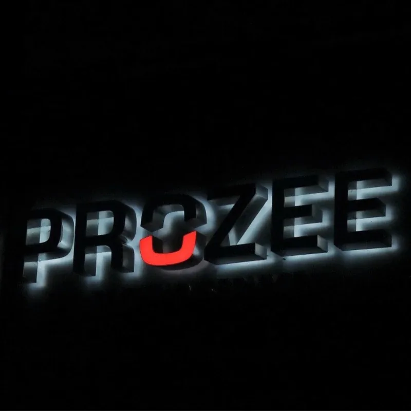 Letters PROZEE met halo-verlichting die tegen de gevel schijnt in het donker