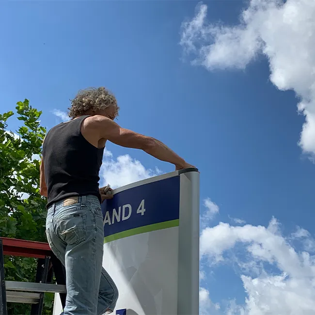 Monteur van Sign Company plaatst een grote geveltekst