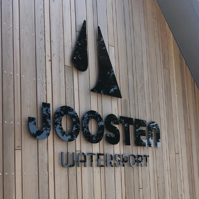 Gefreesde kunststof letters op een houten wand