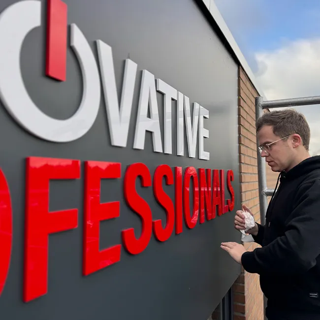 Montage van rode gefreesde letters door een installateur