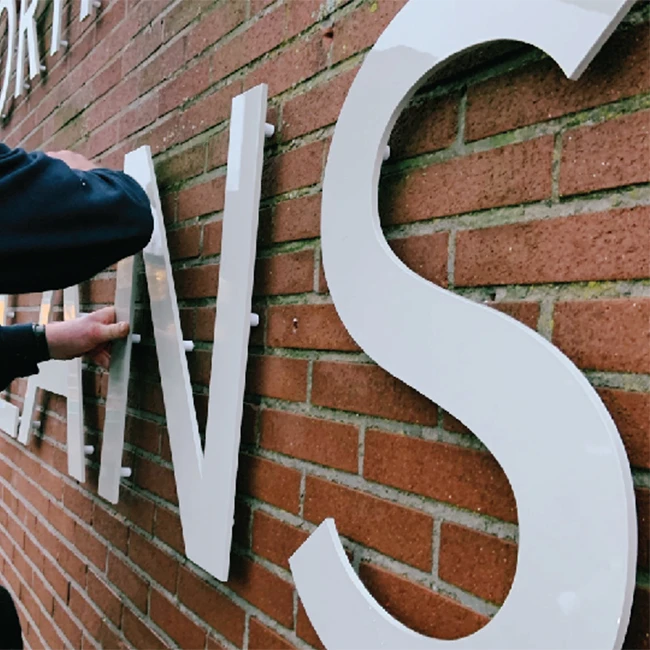 Montage van de kunststof geveltekst bij het Martinus College