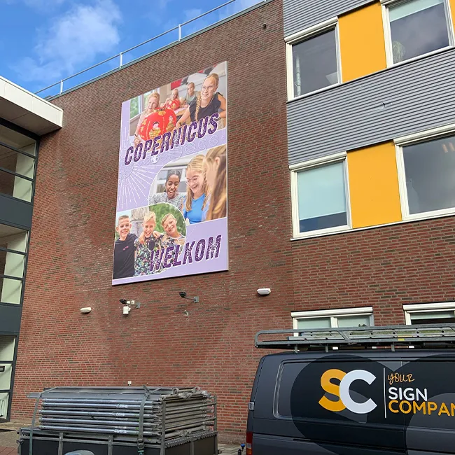 Spandoekframe met promotiedoek op de gevel van een woningbouwproject