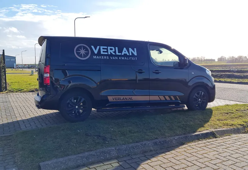 Donkere personenauto met zakelijke belettering in Enkhuizen