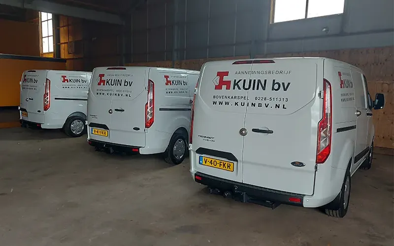 Meerdere bestelbussen van hetzelfde bedrijf naast elkaar in dezelfde huisstijl