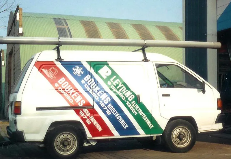 Auto met oude belettering die wordt verwijderd door Sign Company