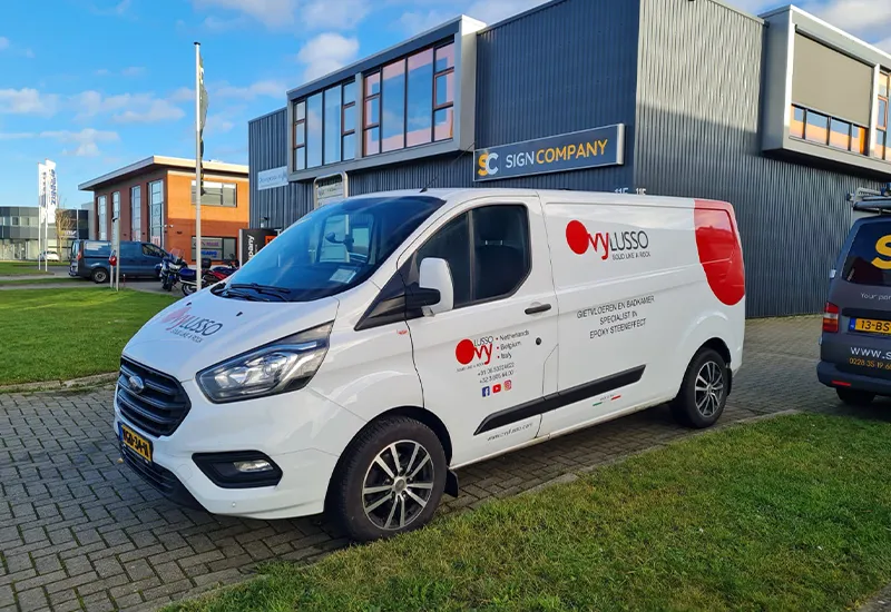 Witte bedrijfsbus met blauwe bestickering in Lelystad