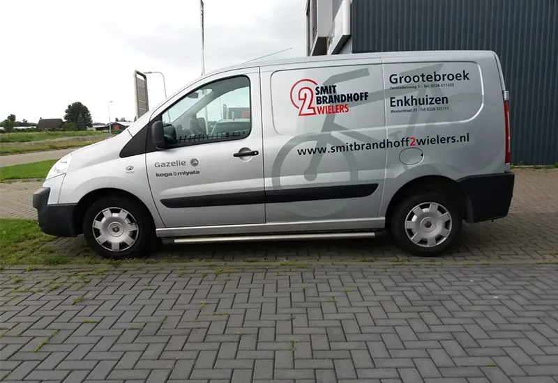 Witte compacte bestelbus met grijze belettering van Smit Brandhoff 2wielers uit Grootebroek en Enkhuizen