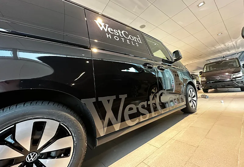 Zwarte personenauto met strakke belettering