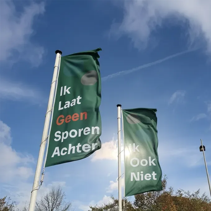 Twee groene vlaggen met de tekst Ik laat geen sporen achter
