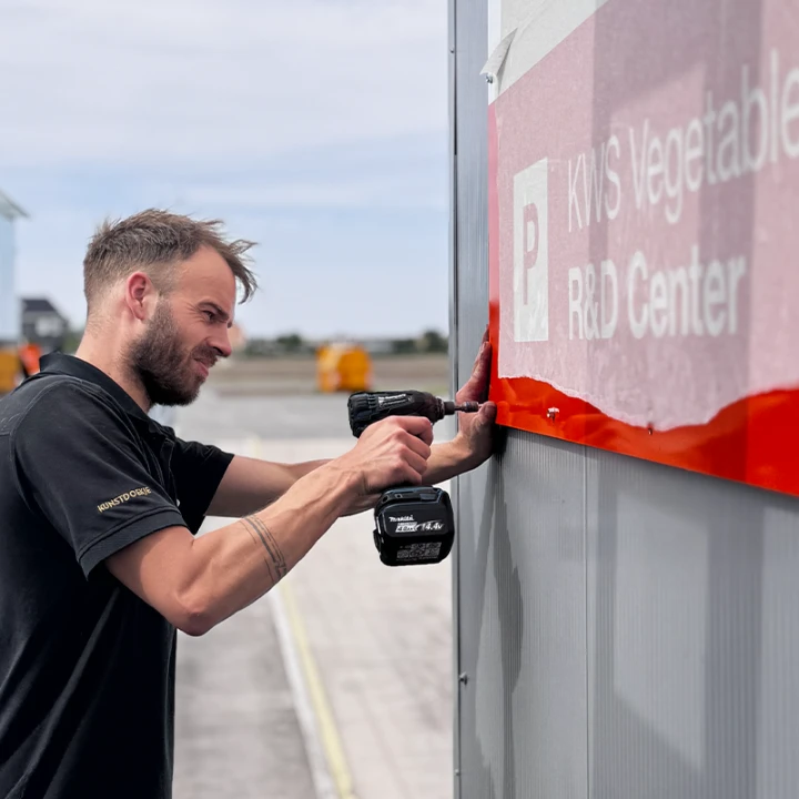 Sign company monteur installeert gevelreclame boormachine - Gevelreclame Sign Company
