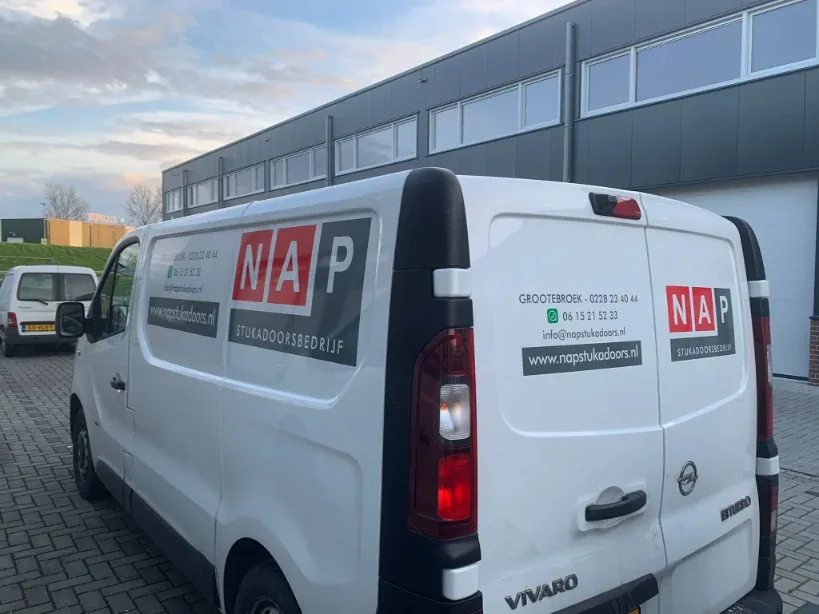 Achterdeuren van een witte bestelbus met het logo en de contactgegevens van NAP Stukadoorsbedrijf