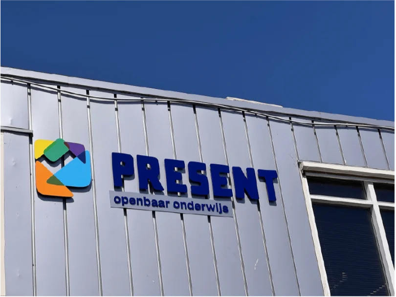 Freesletters op de gevel van Present