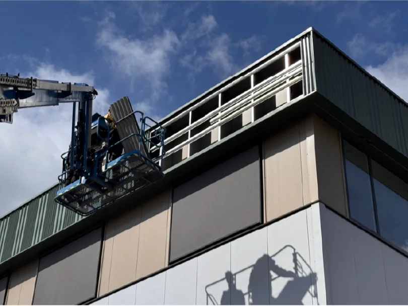 Monteur van Sign Company plaatst lichtreclame met een hoogwerker