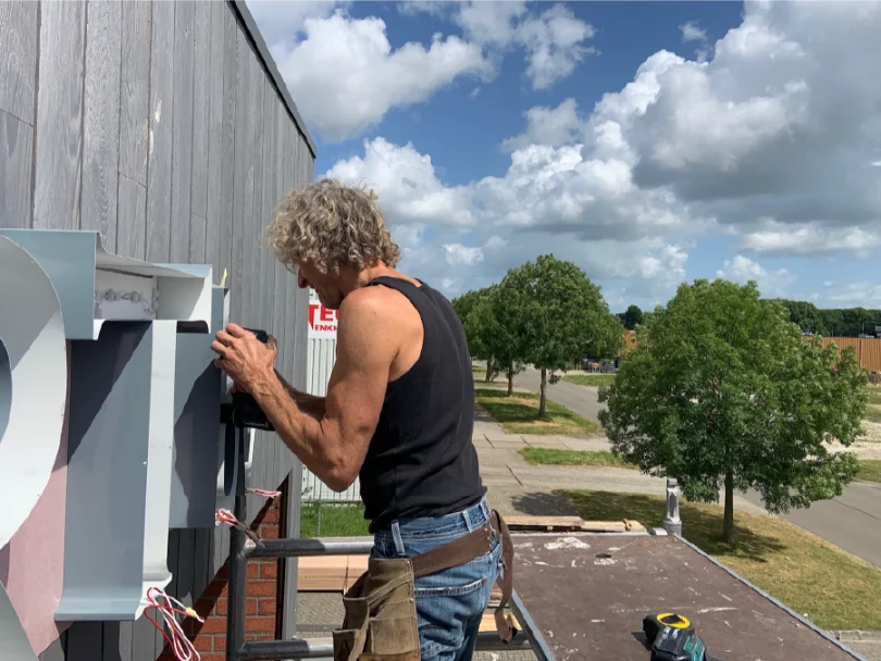 Installatie van de lichtreclame bij Houtexpert