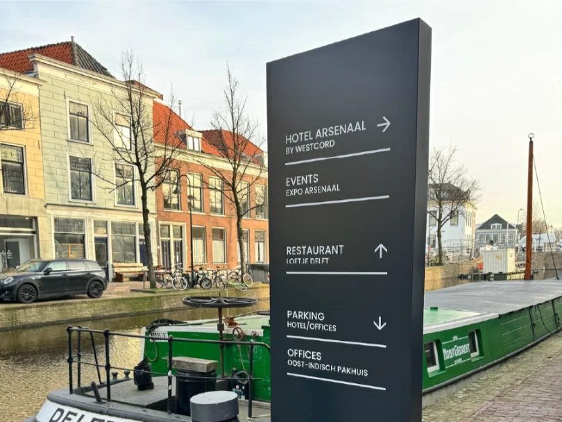 Zwarte informatiezuil van Hotel Arsenaal aan de gracht in Delft