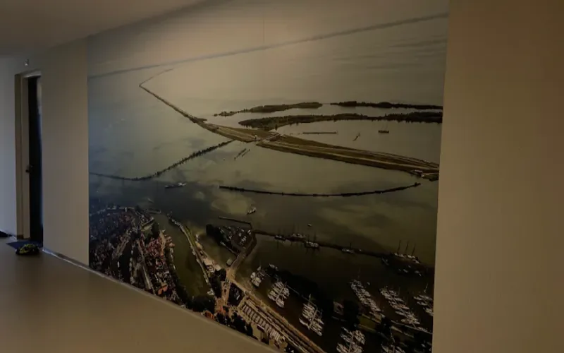 Wandvullende wandprint met een luchtfoto van een haven in een gang