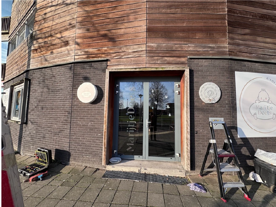 Monteur plaatst gevelletters BSO Almere