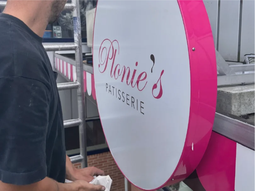 Ovaal uithangbord Plonies Patisserie montage