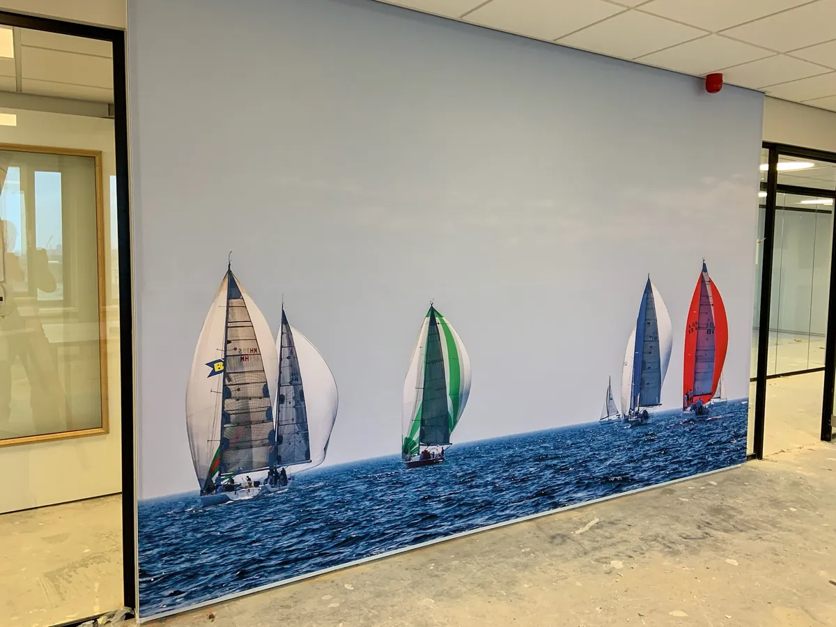 Wandvullende print van zeilboten op blauw water in een kantoor