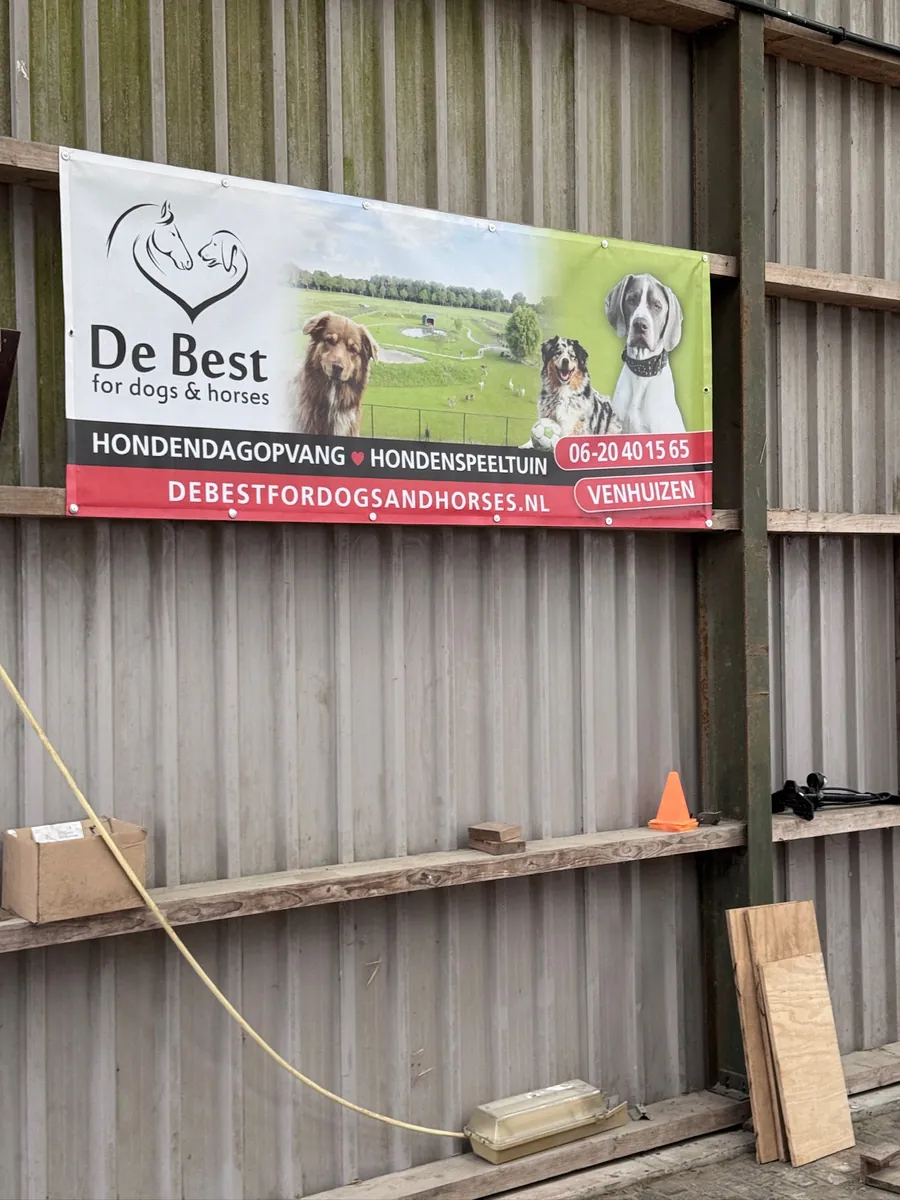 Spandoek van De Best for dogs & horses aan een houten schuur