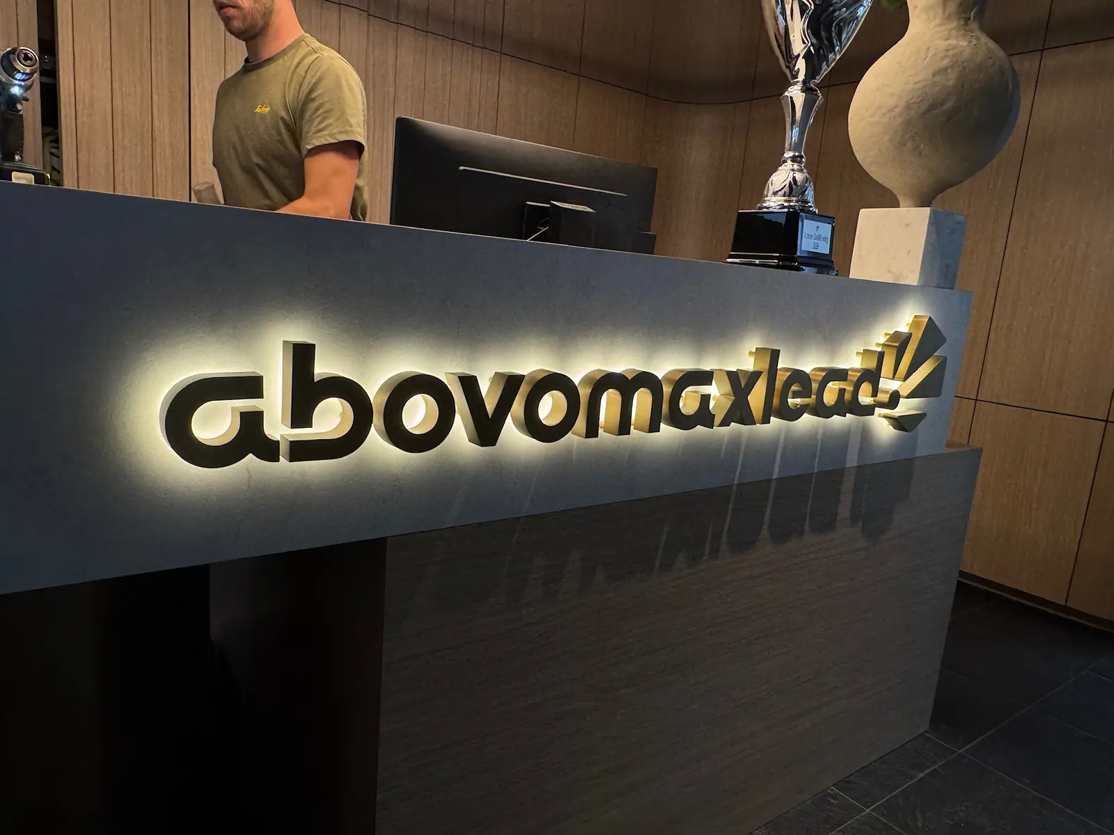 Letters van abovomaxlead met warm licht erachter op de receptiebalie