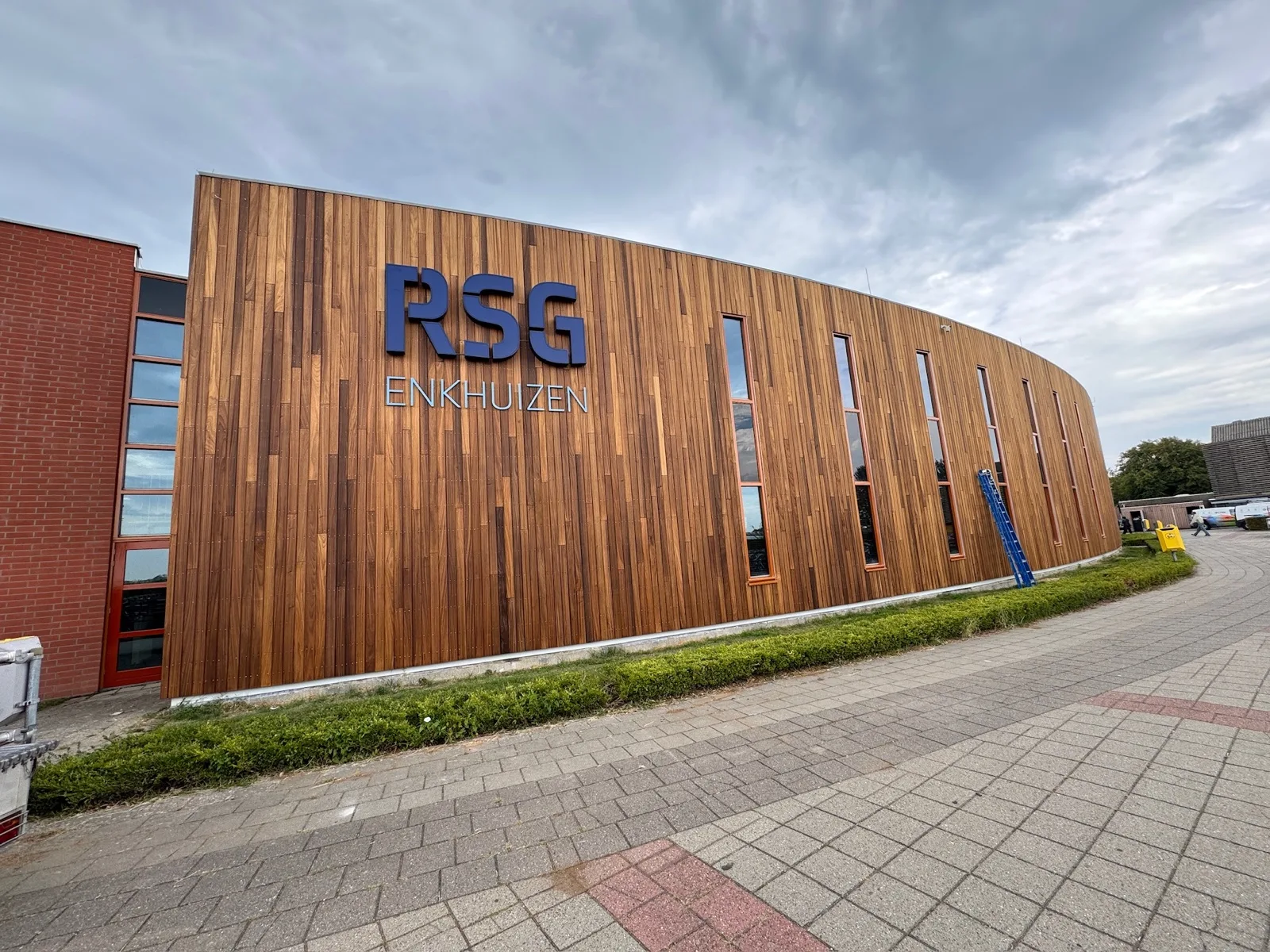 Blauwe letters RSG Enkhuizen op de gebogen houten gevel van de school