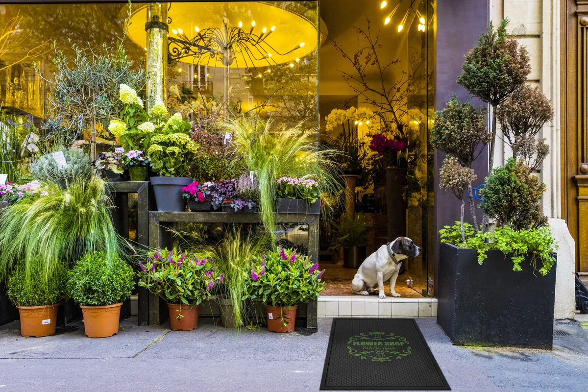 Rubber schraapmat met logo op de stoep voor een bloemenwinkel