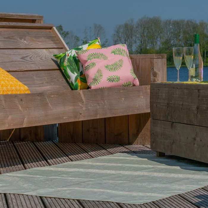 Bedrukte sierkussens buiten, sfeerbeeld op een houten terras aan het water