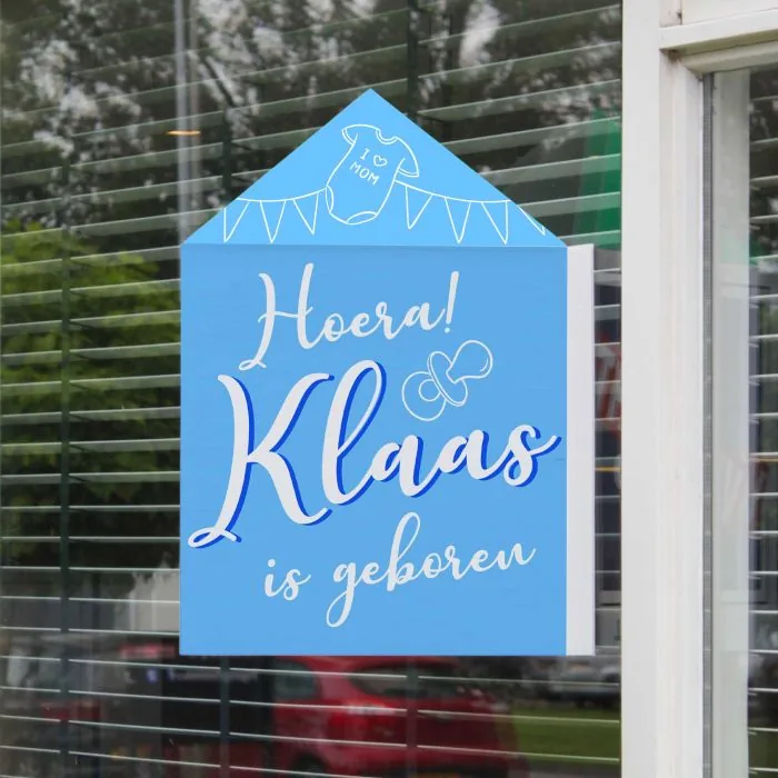 Blauw geboortebord met de naam Klaas tegen het raam