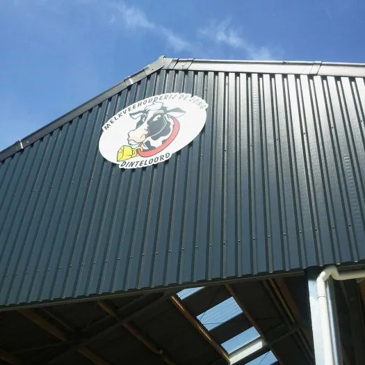 Rond gevelbord met bedrijfslogo hoog op de gevel