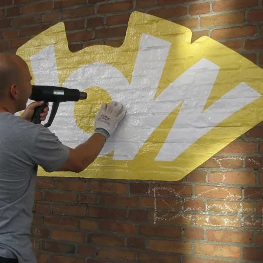 Muursticker die met warmtepistool wordt aangebracht