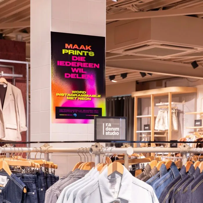 NeonPrint poster bij kledingrekken in een winkelinterieur
