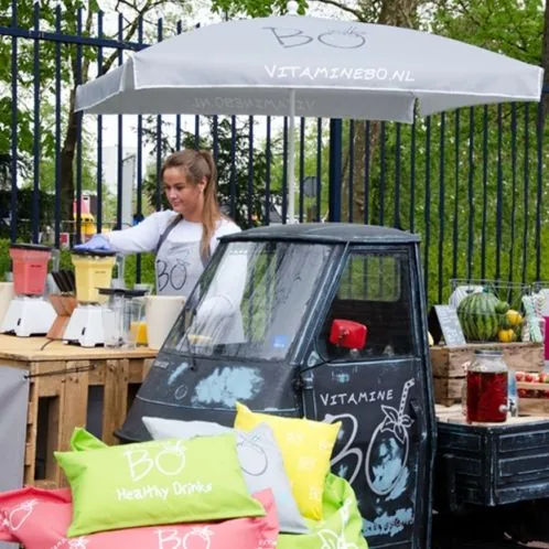 Bedrukte parasol met logo bij een horecakraam op een evenement