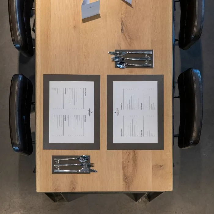 Placemats en bestekhoesjes met huisstijl, bovenaanzicht van een gedekte tafel