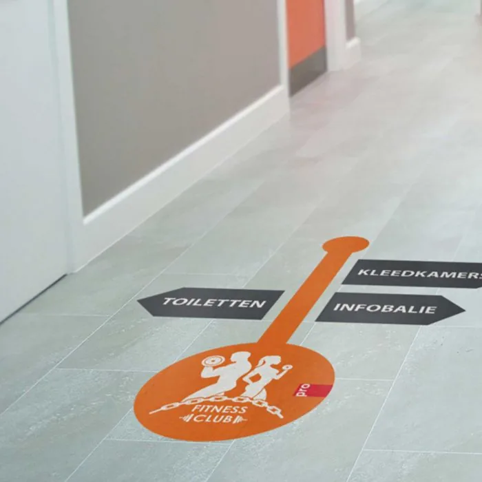 Vloersticker met bewegwijzering in een fitnessclub