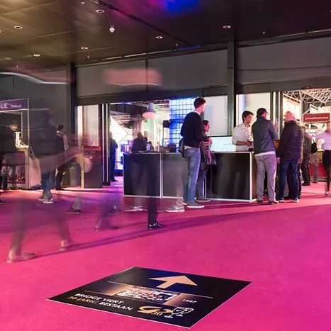 Vloersticker met pijl en logo op een eventvloer