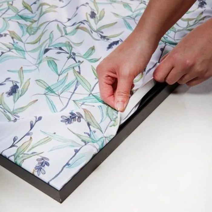 Detail van het bedrukte doek dat in het profiel van het wandframe wordt geklikt