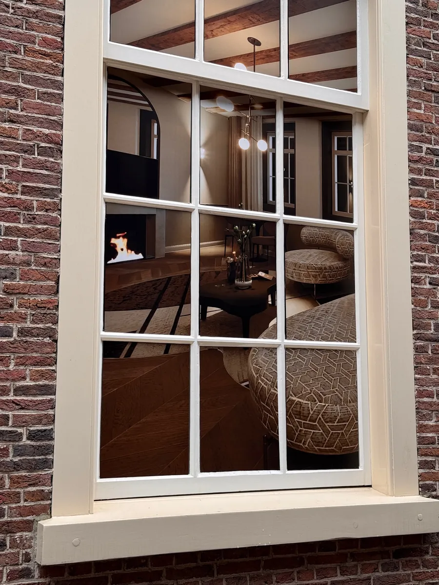 Raam met een print van een hotelinterieur achter de roeden