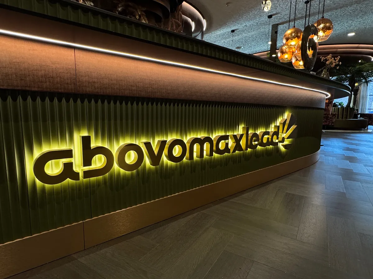 Gebogen balie met verlichte letters abovomaxlead in de lobby