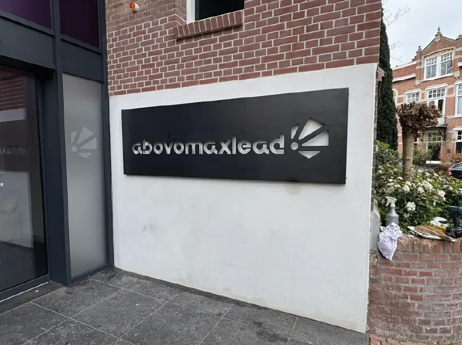 Logo en letters op de groene wand bij Abovomaxlead
