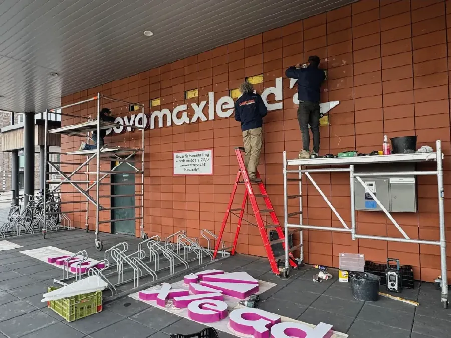 Montage van de letters op het metselwerk bij Abovomaxlead